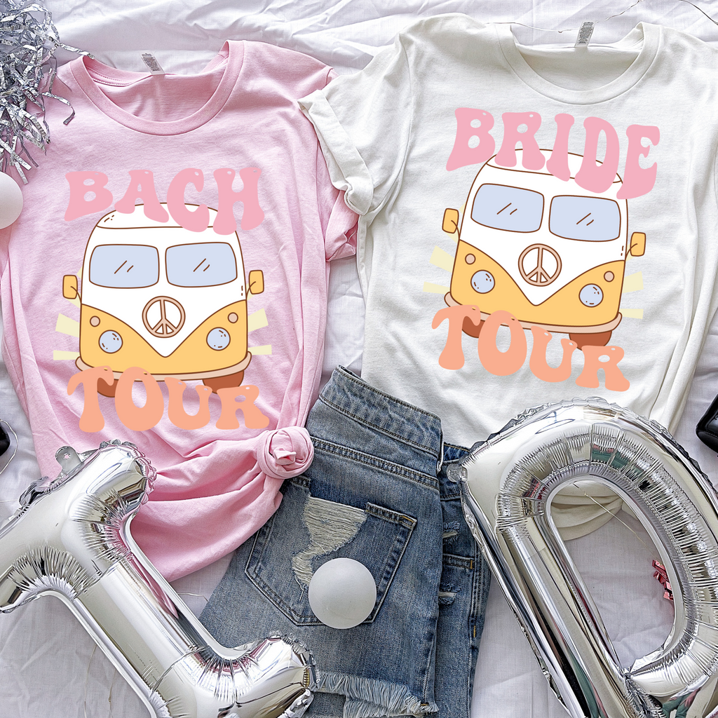 Pink shirt with "bach tour" and white shirt with"bride tour" written on with a vintage bus