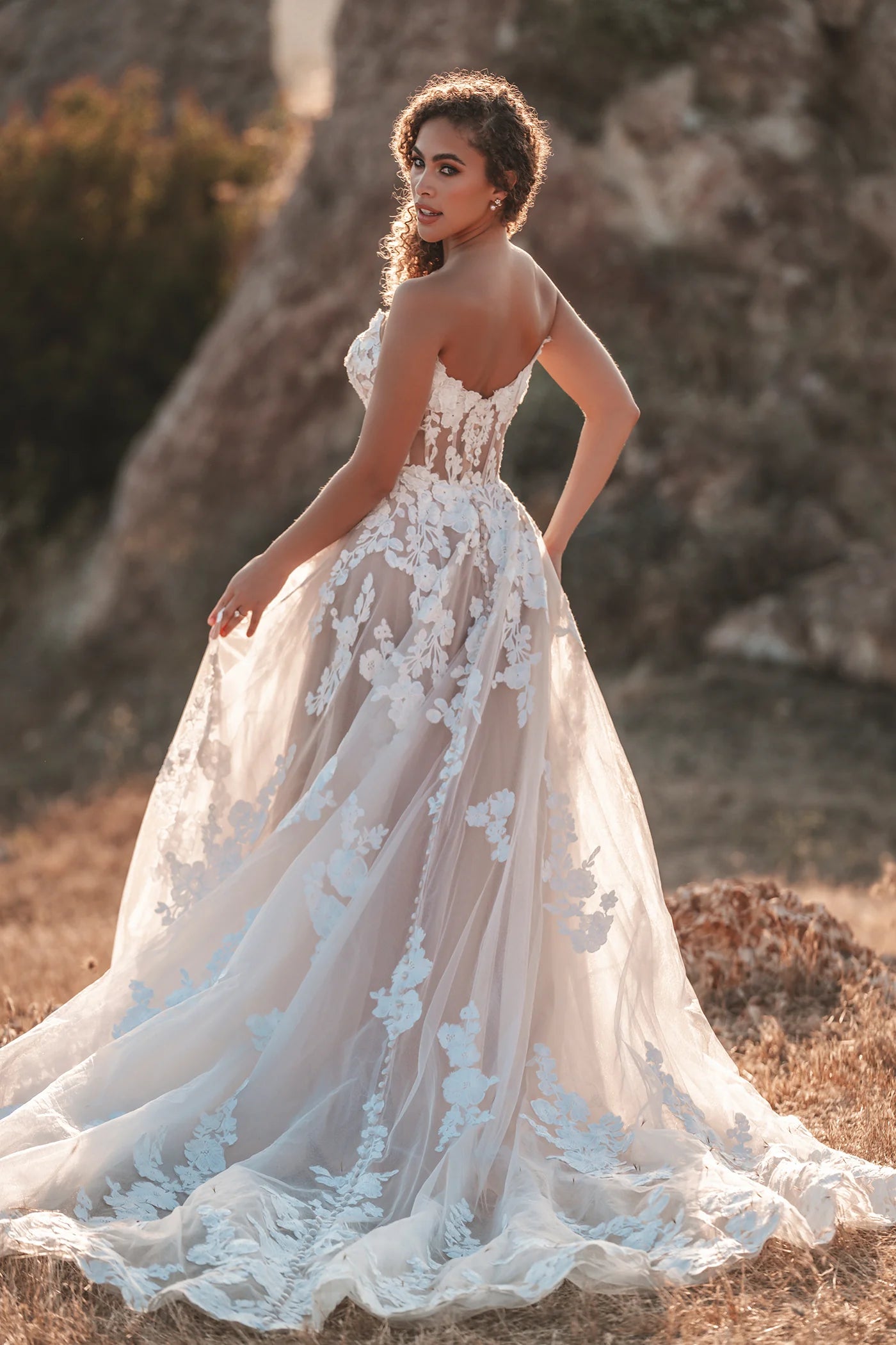 Finished with a pair of coordinating detachable sleeves, this shimmering, A-line tulle gown features soft matte lace appliques throughout.