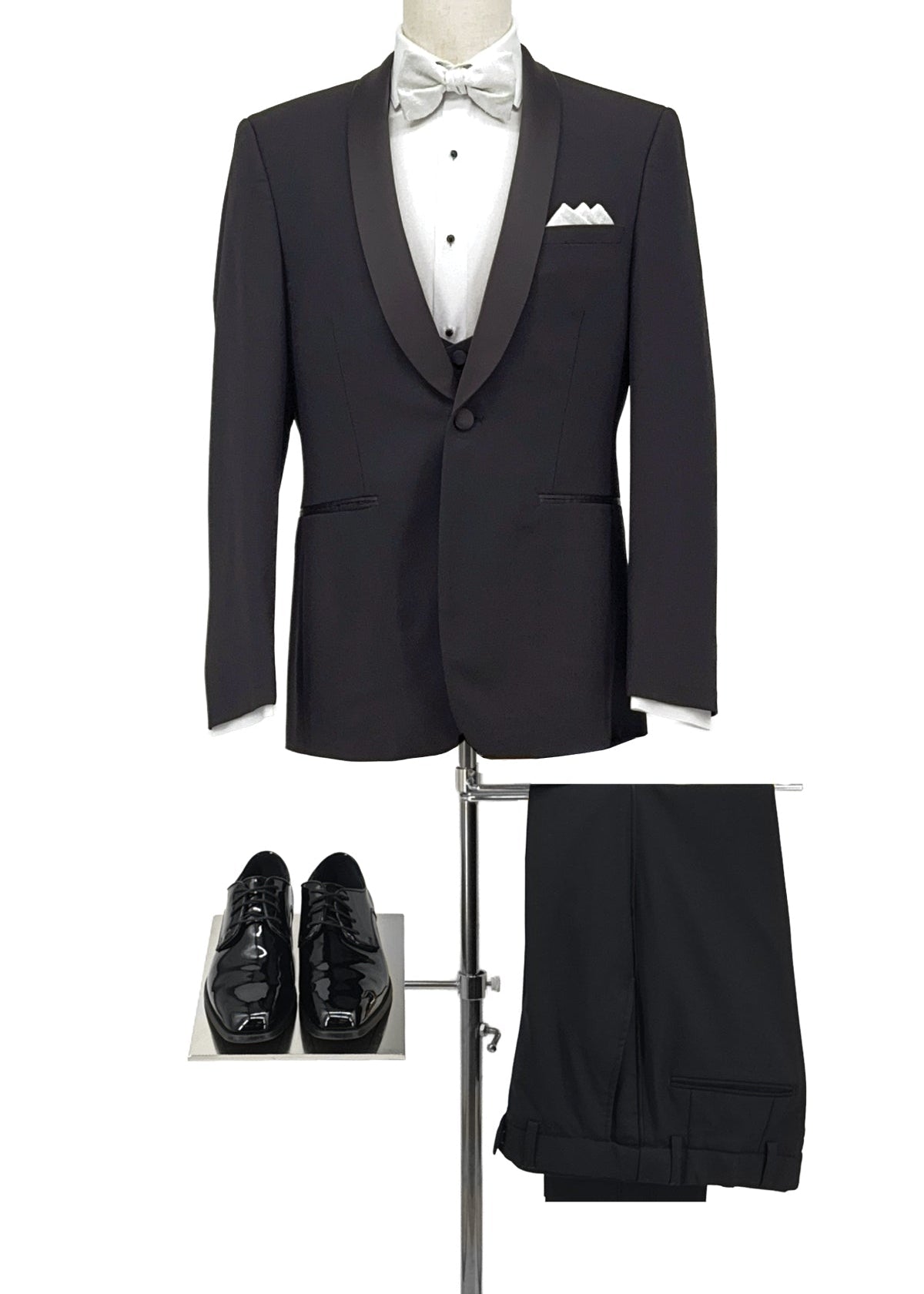 Black tuxedo with white shirt, bow tie, and pants on a stand with shoes below.