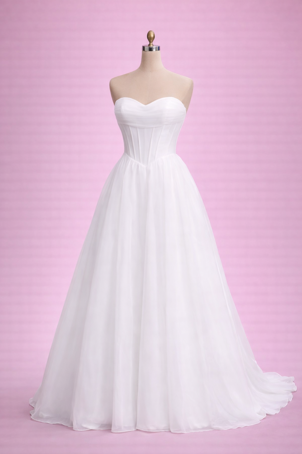 White wedding dress on a mannequin against a pink background