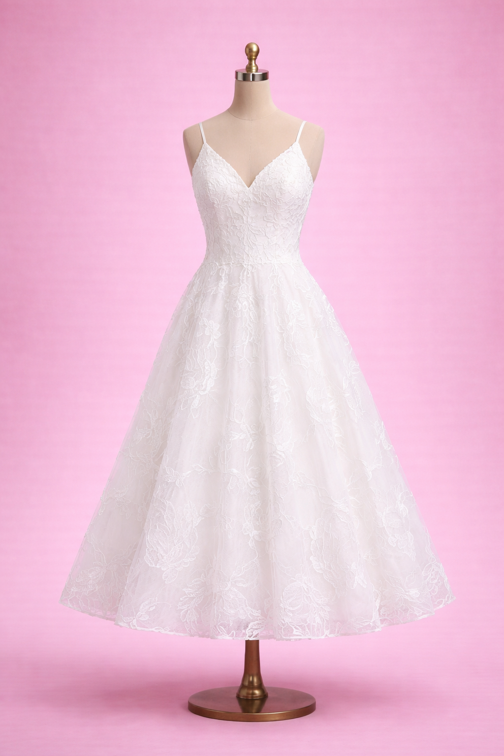 White lace dress on a mannequin against a pink background
