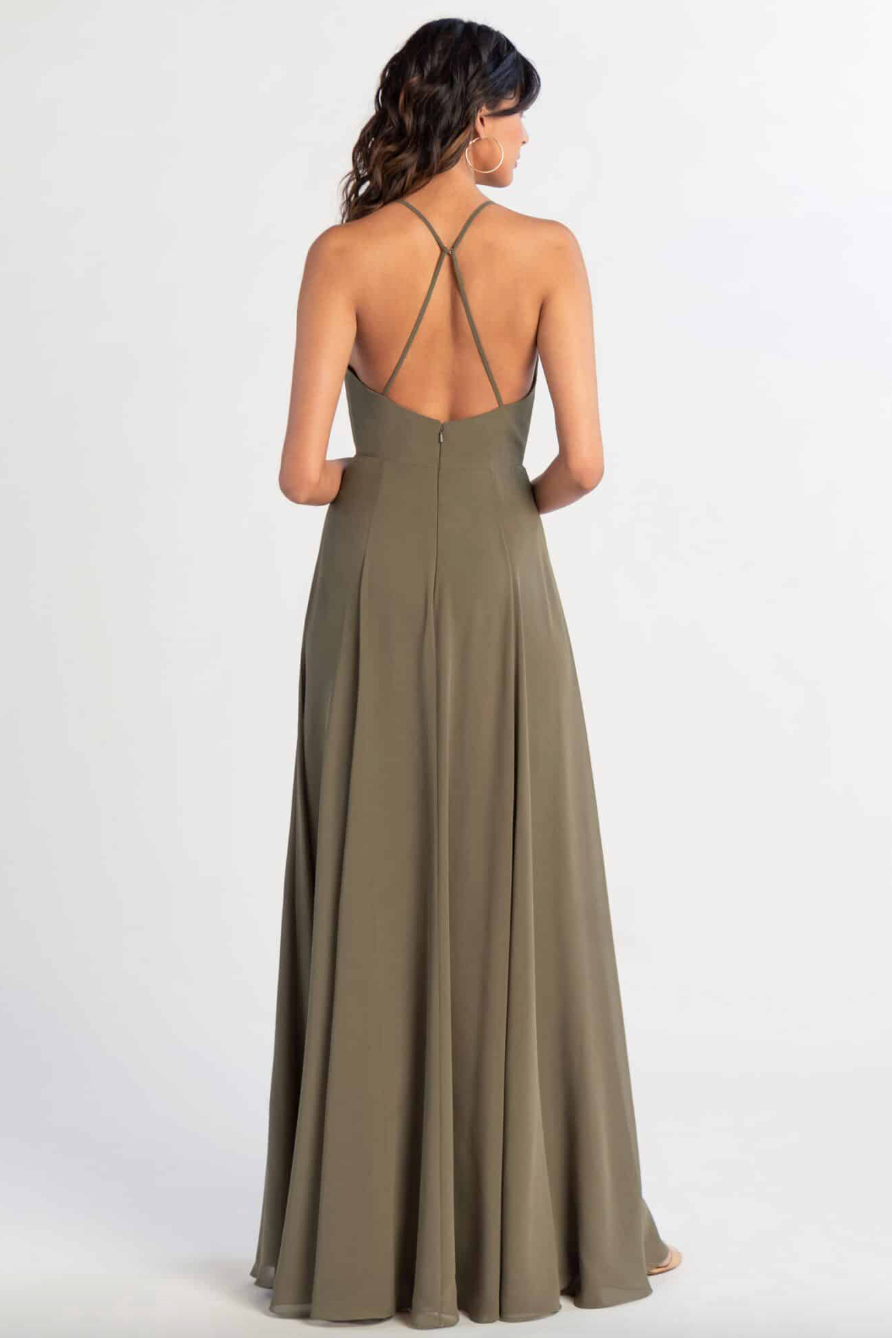 Woman wearing a long olive green dress with thin straps on a white background