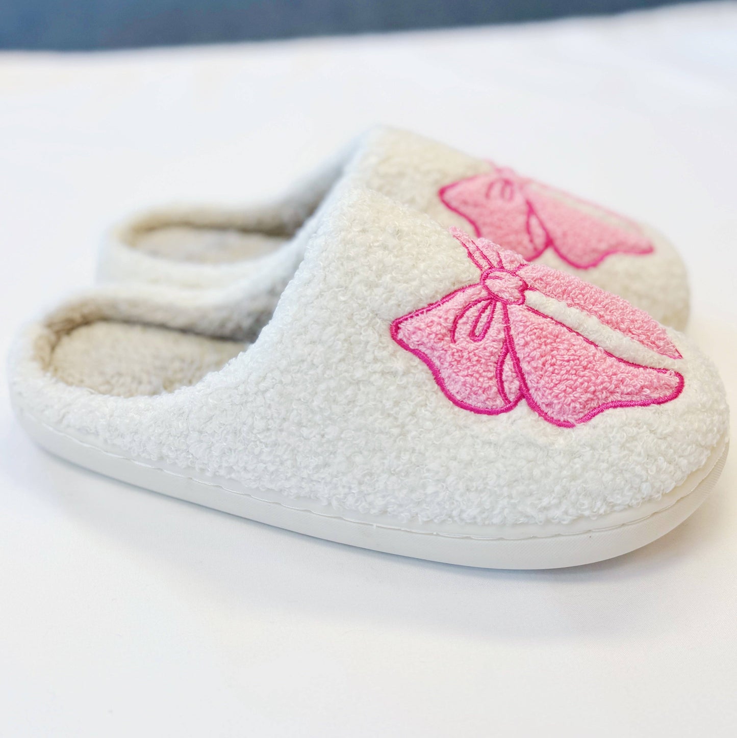White slippers with a pink bow
