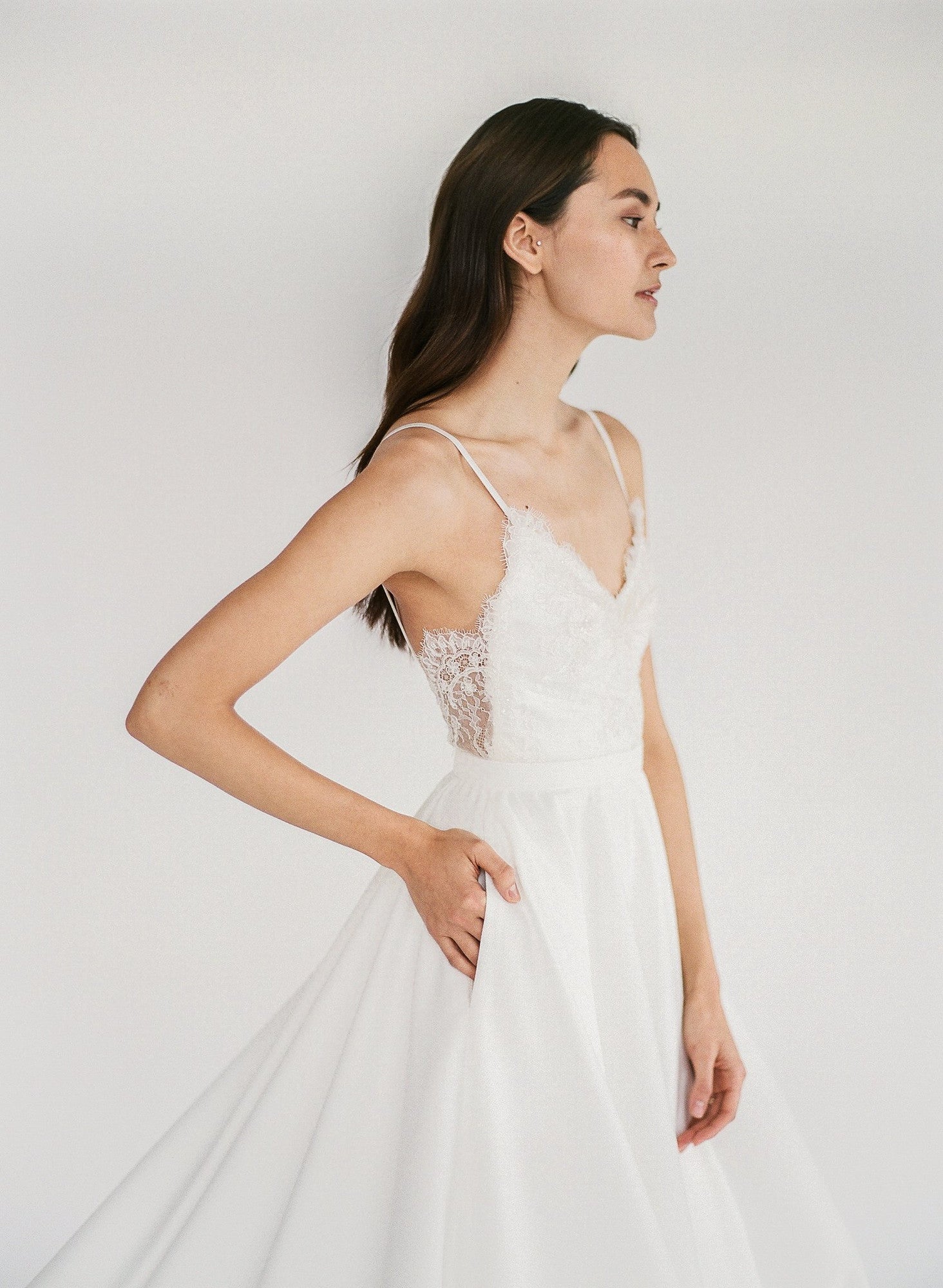 Trisha - an a-line white wedding dress with spaghetti straps and a lace v-neck bodice - close up side view