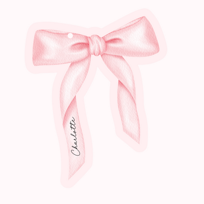 Pink bow with a name tag on a white background