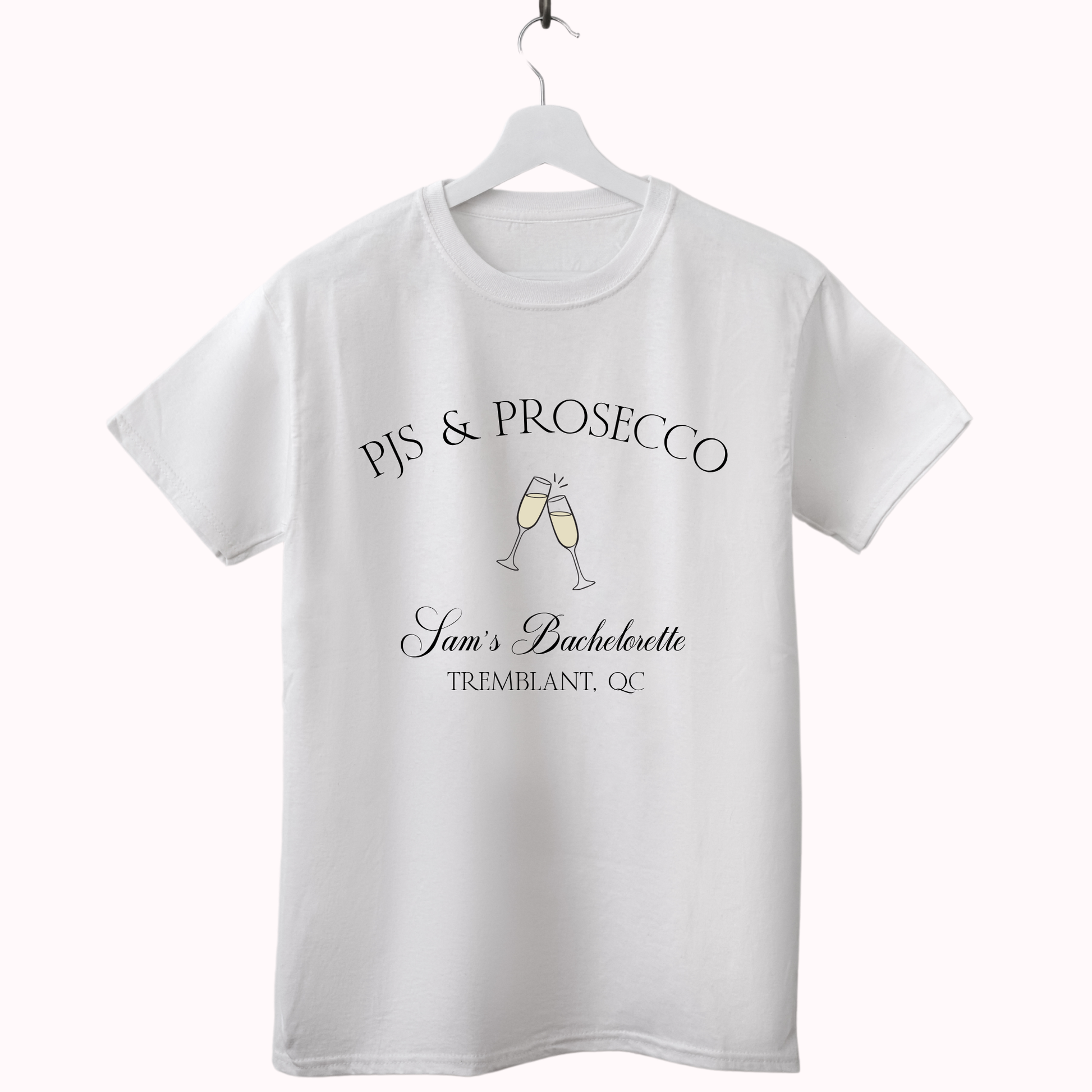 White t-shirt with 'PJs & Prosecco' text and champagne glass design on a hanger against a white background