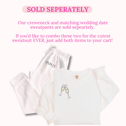 White sweatshirt and pants with champagne glass design and text on a white background