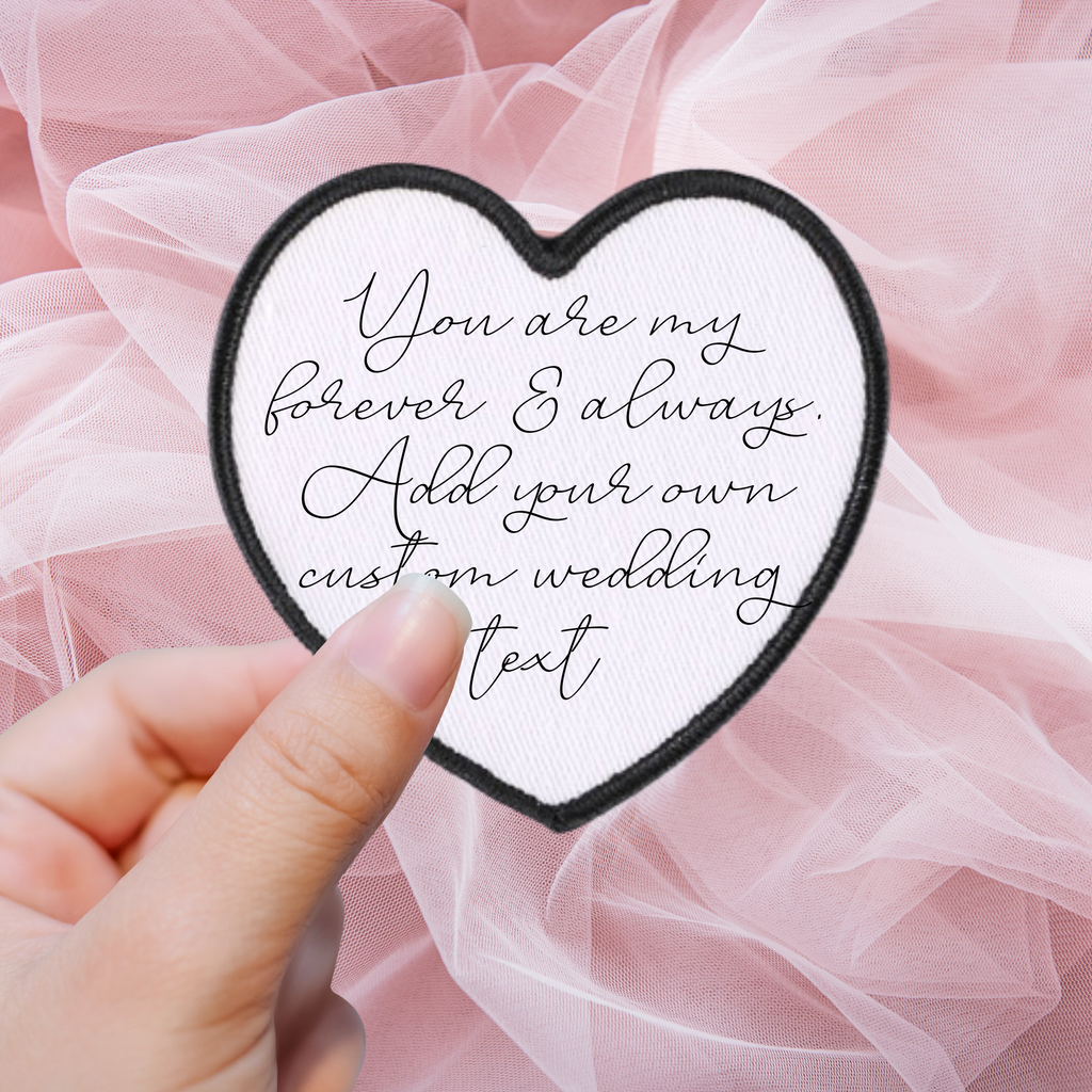 A white heart shaped patch with "you are my forever & always add your own custom wedding text" written in calligraphy black