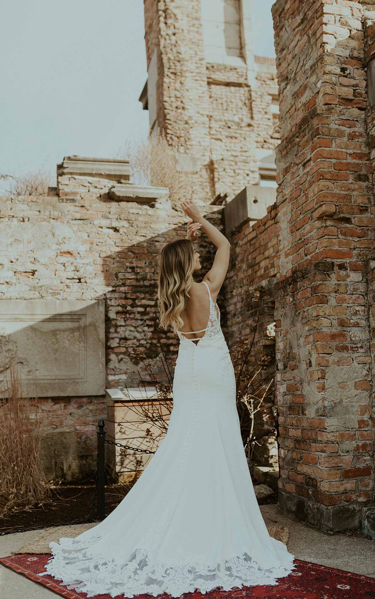 Woman wearing a long lace fitted wedding dress back view