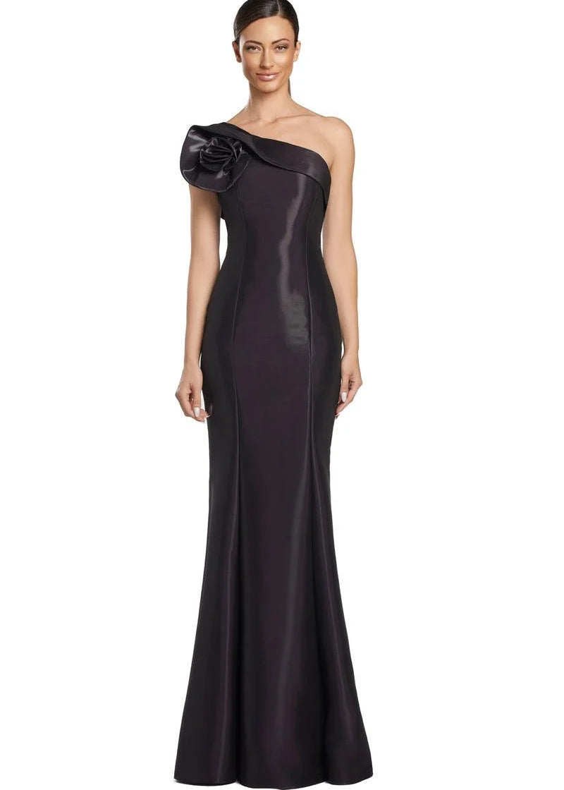 Woman wearing a dark purple one-shoulder gown with a floral detail on a white background