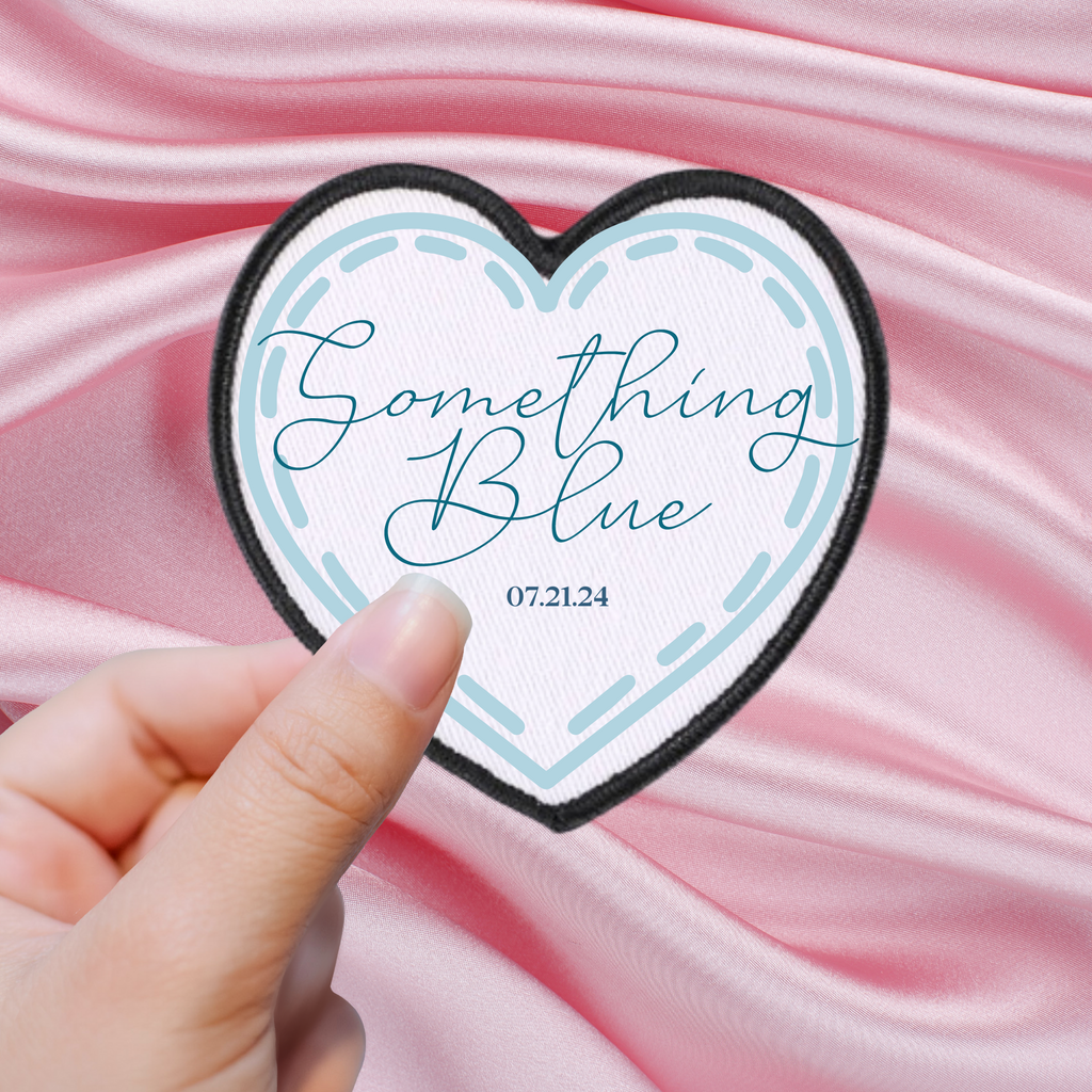 A white heart patch with "something blue 07.21.24" written in blue