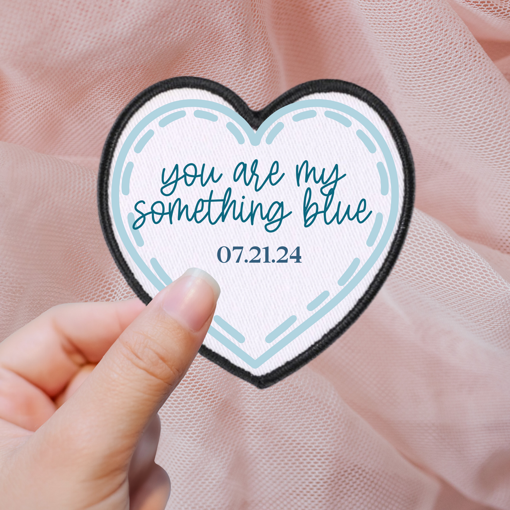 A white heart patch with "you are my something blue 07.21.24" written in blue