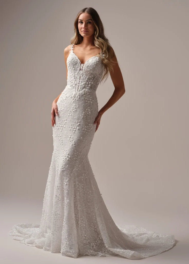 Wedding Dresses | The Isabella wedding gown, available in our curvy fit, is designed to celebrate your shape with confidence and elegance. This flattering fit-and-flare silhouette hugs in all the right places, while delicate floral lace cascades from bodice to hem for a romantic finish. A plunging neckline with illusion straps adds modern allure, and the button-back detail with a flowing train ensures you’ll turn heads from every angle. Perfect for the bride who wants classic beauty with a contemporary twis