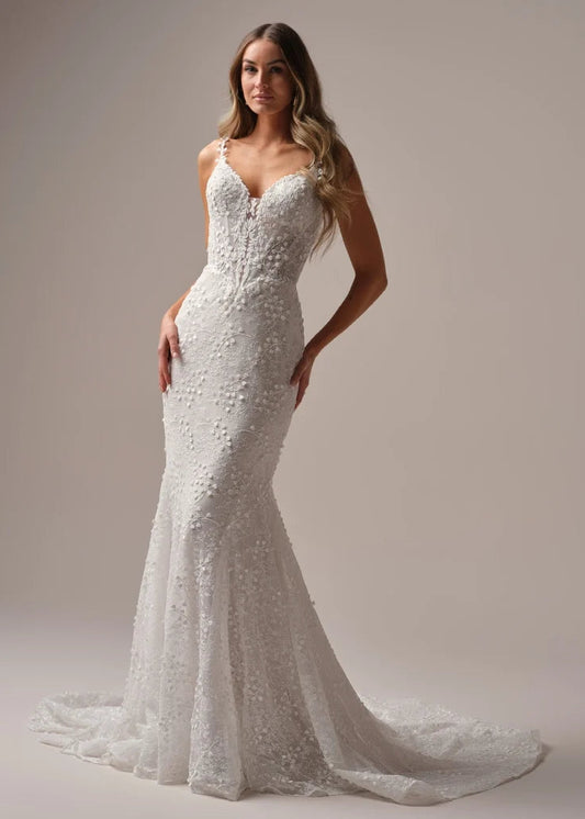 Wedding Dresses | The Isabella wedding gown, available in our curvy fit, is designed to celebrate your shape with confidence and elegance. This flattering fit-and-flare silhouette hugs in all the right places, while delicate floral lace cascades from bodice to hem for a romantic finish. A plunging neckline with illusion straps adds modern allure, and the button-back detail with a flowing train ensures you’ll turn heads from every angle. Perfect for the bride who wants classic beauty with a contemporary twis
