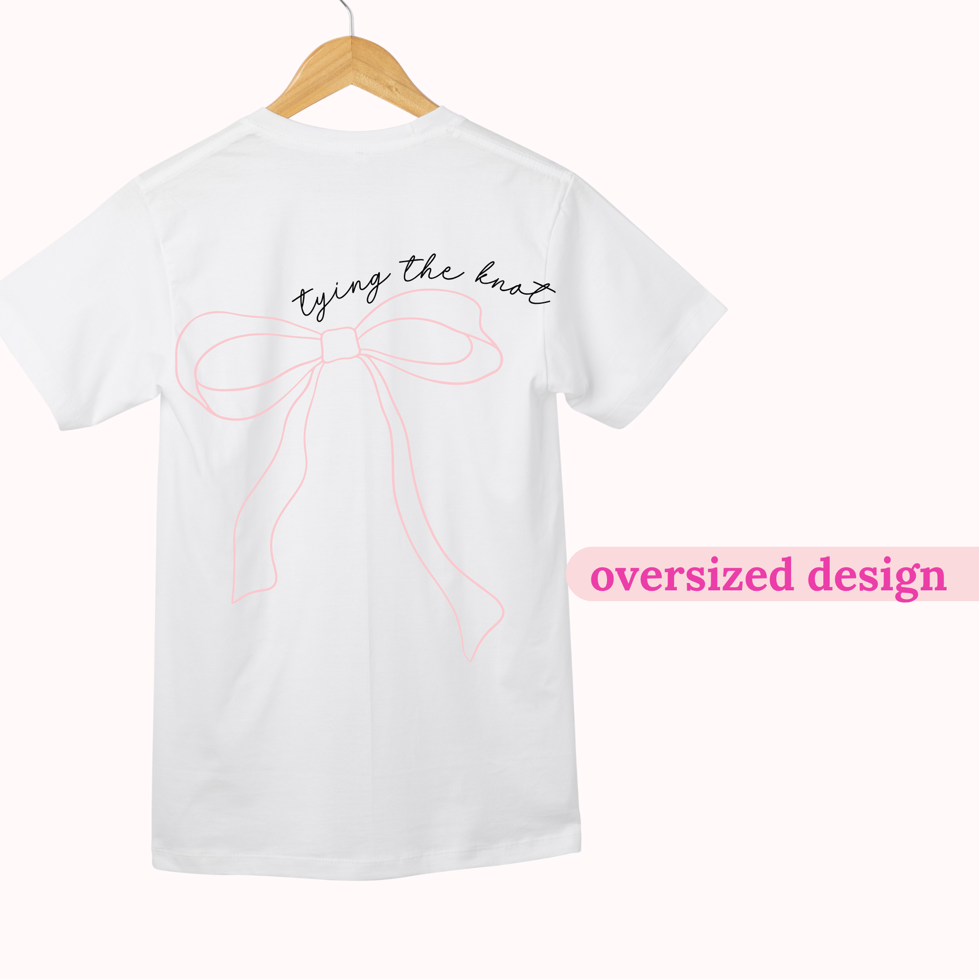White t-shirt with oversized bow design and text on a hanger