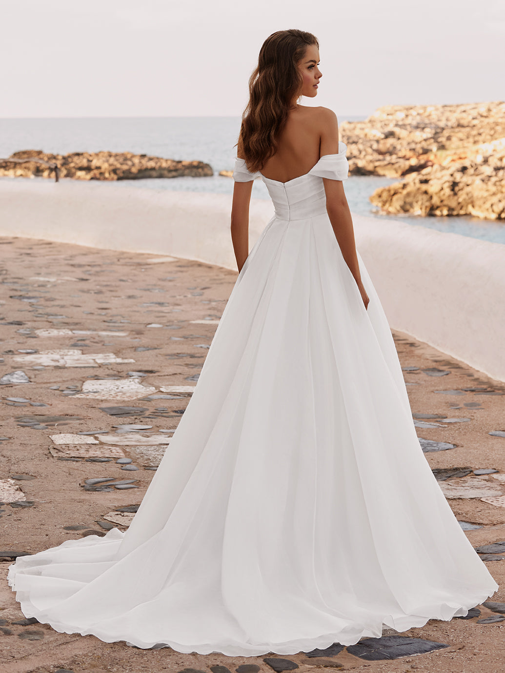 Introducing the DAISIE gown, crafted from delicate organza fabric with a draped bodice that accentuates your silhouette. Its off-the-shoulder straps exude timeless romance, framing your shoulders with elegance. The sweetheart neckline adds a touch of classic allure.

