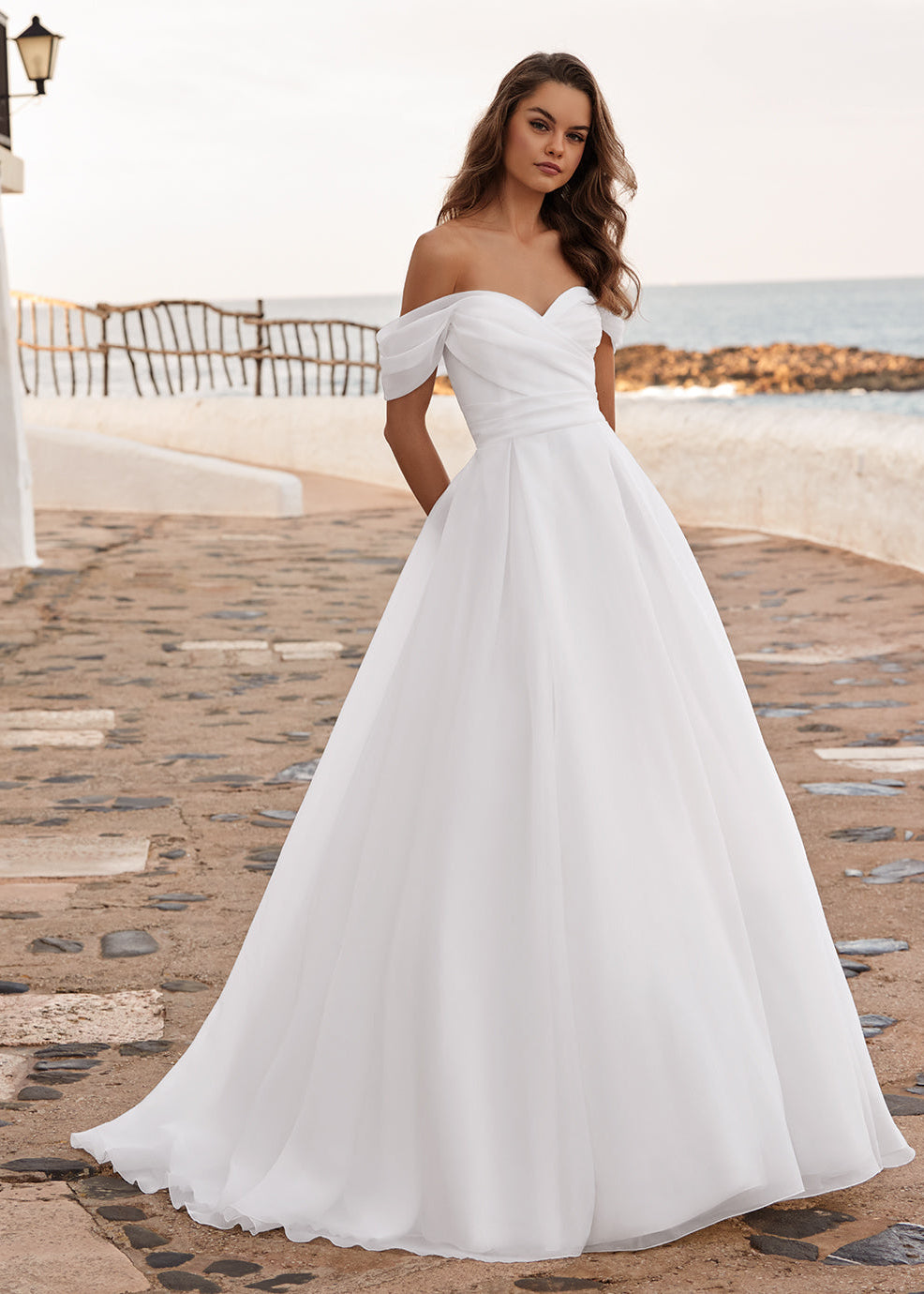 Introducing the DAISIE gown, crafted from delicate organza fabric with a draped bodice that accentuates your silhouette. Its off-the-shoulder straps exude timeless romance, framing your shoulders with elegance. The sweetheart neckline adds a touch of classic allure.

