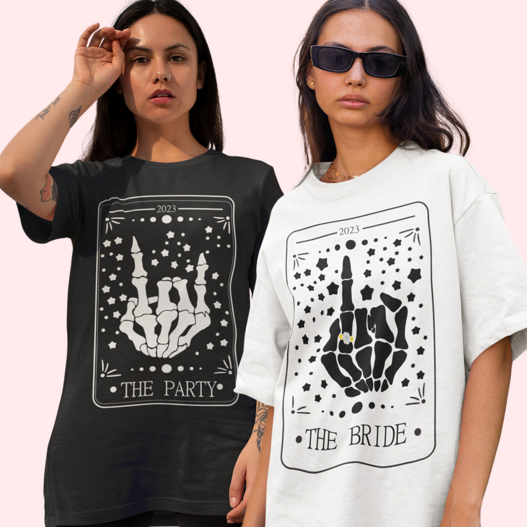 2 women, one is wearing a black shirt with "the party" and a skeleton hand and white shirt with "the bride" with a skeleton hand and a ring on it