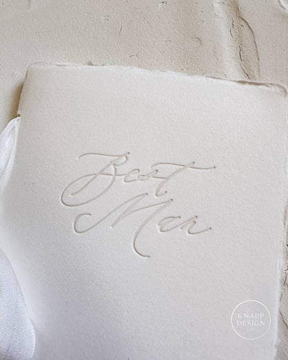 Picture of a white vow book with "best man" written on the front