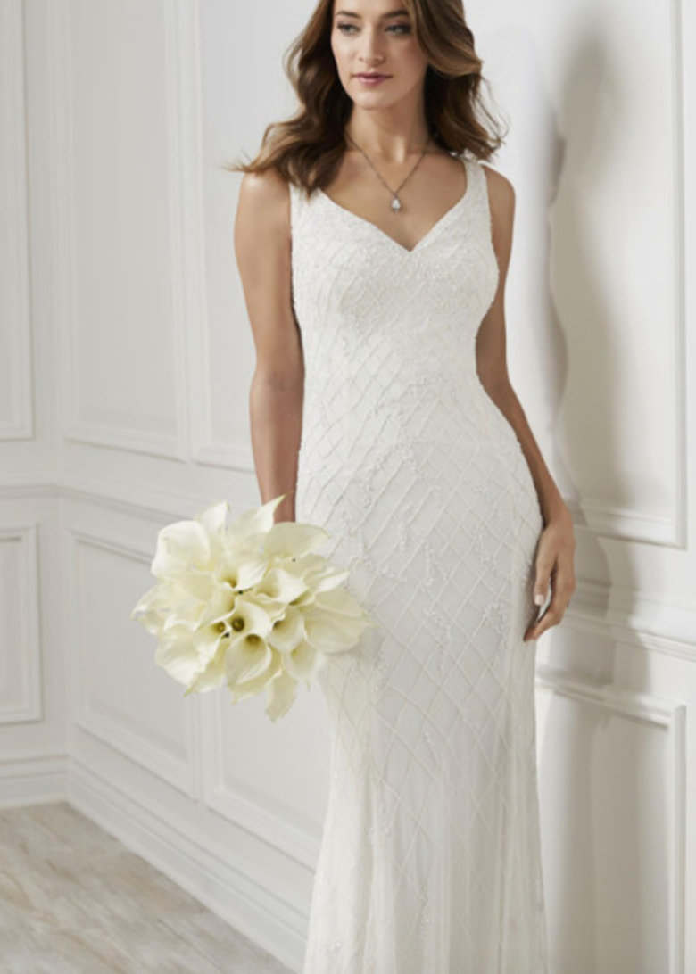 Young woman wearing a white sparkly dress with a v neck and thick straps