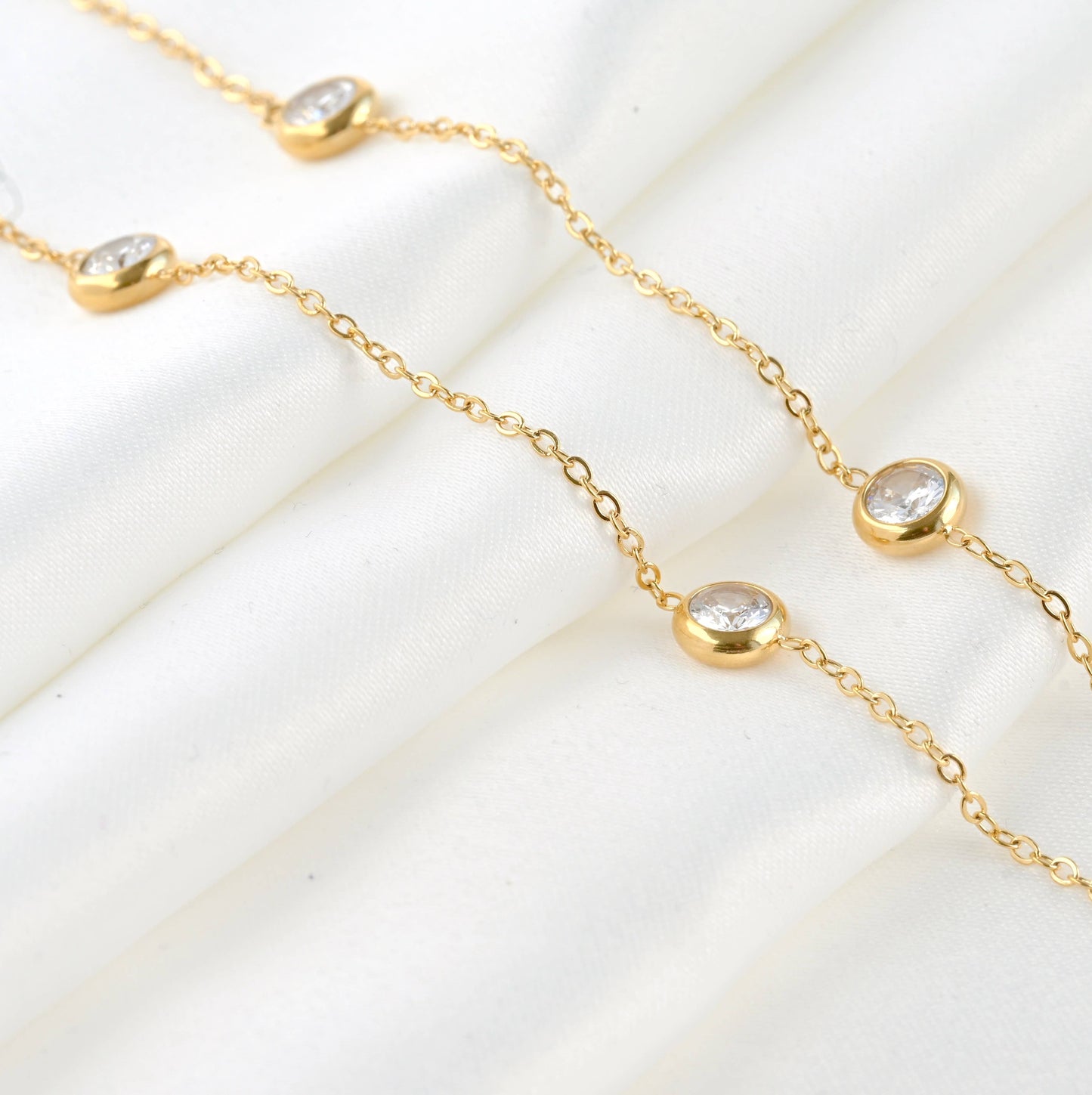 Bezel necklace laying on a white sheet