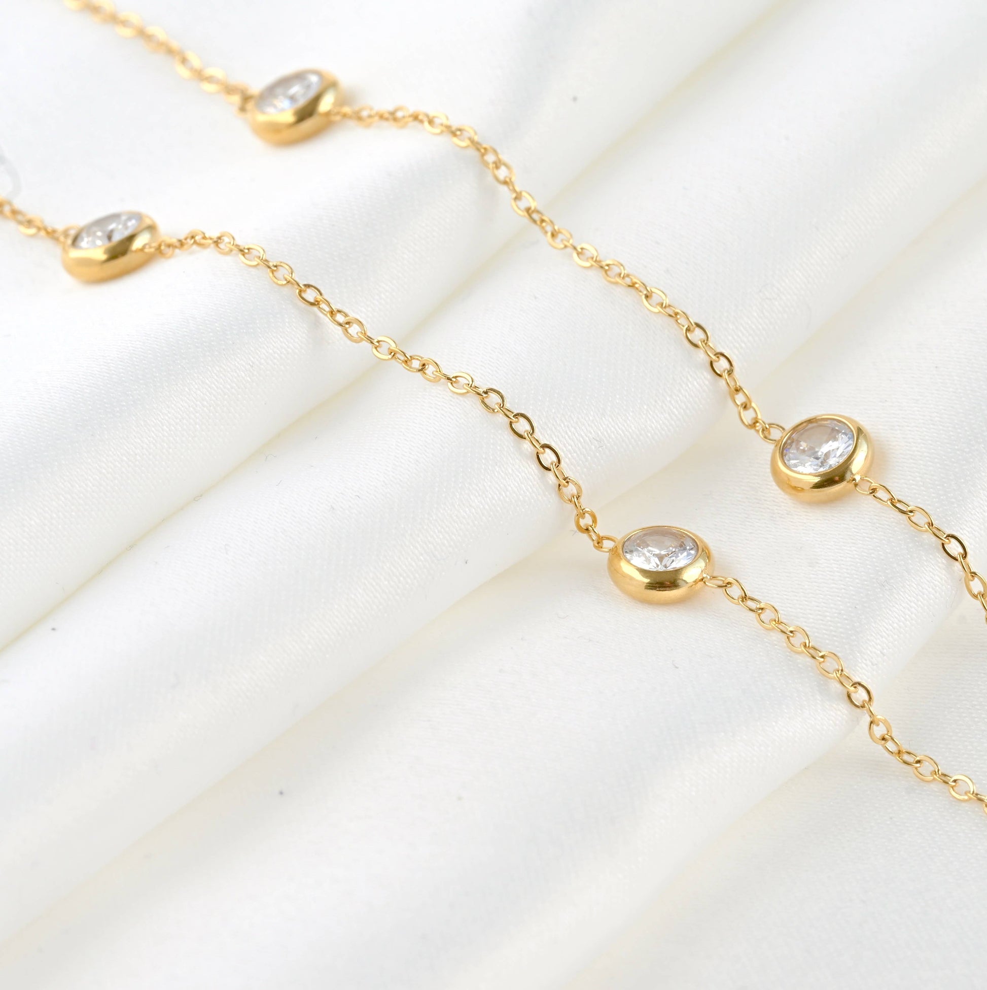 Bezel necklace laying on a white sheet