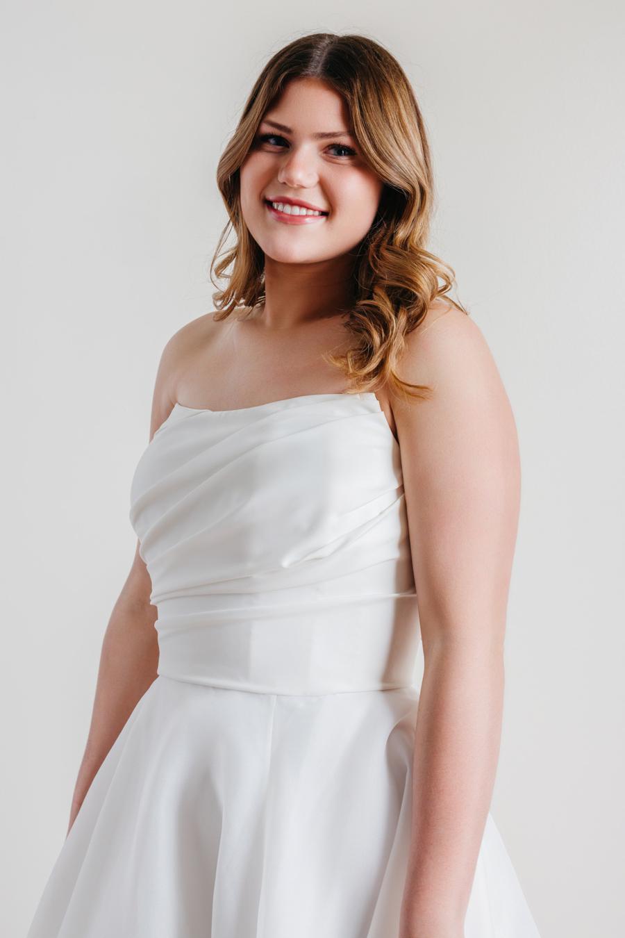 Introducing Fortune, the epitome of elegance and sophistication in bridal fashion. This exquisite wedding dress boasts a timeless strapless design, crafted with meticulous attention to detail. Its luxurious blend of Cyrus Stretch Crepe and Sluler Satin Organza fabrics creates a breathtaking A-line silhouette that will make any bride feel like a true vision of romance on her special day. 