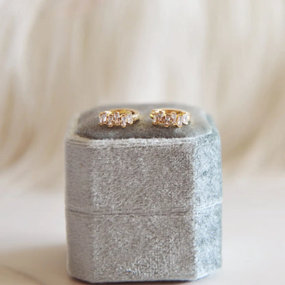 Sunny Huggie Hoops - gold mini hoops on a grey ring box
