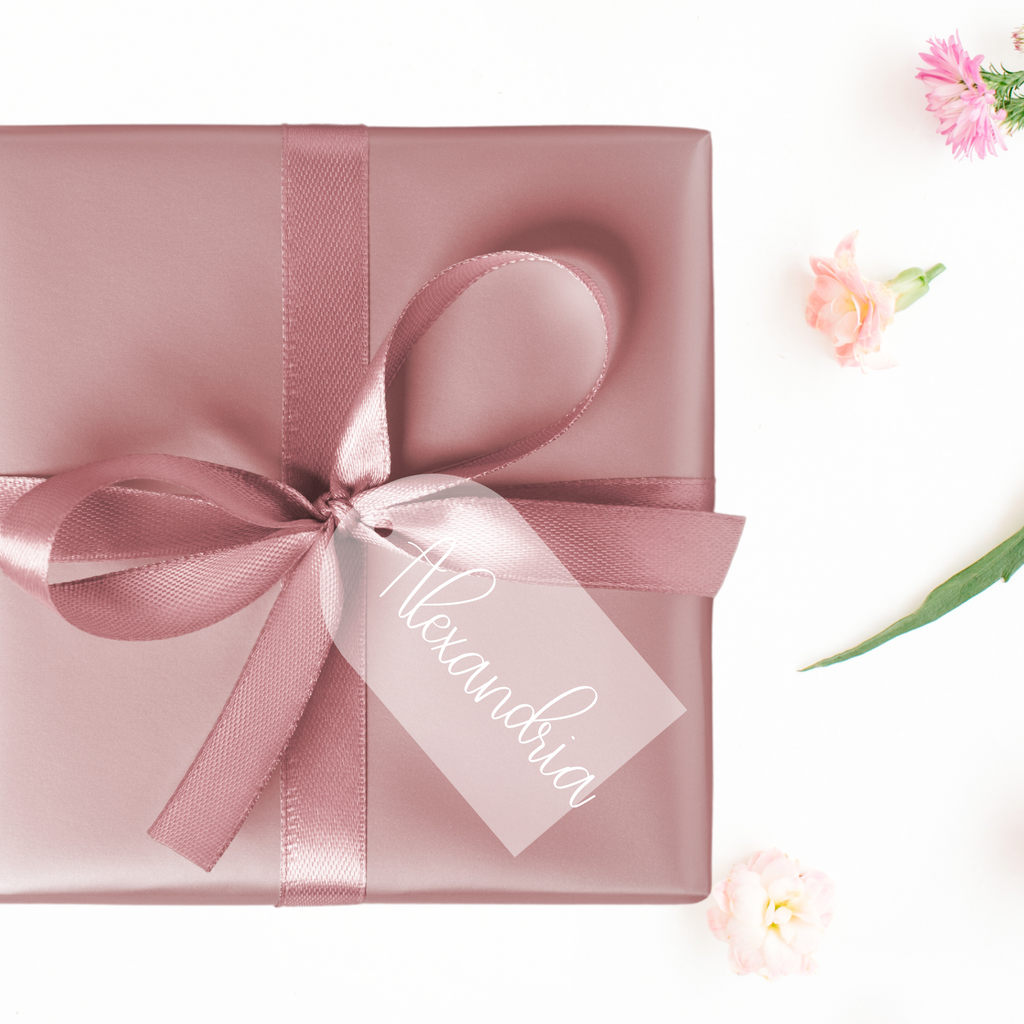 A pink wrapped gift box with acrylic tag and "Alexandria" written on it