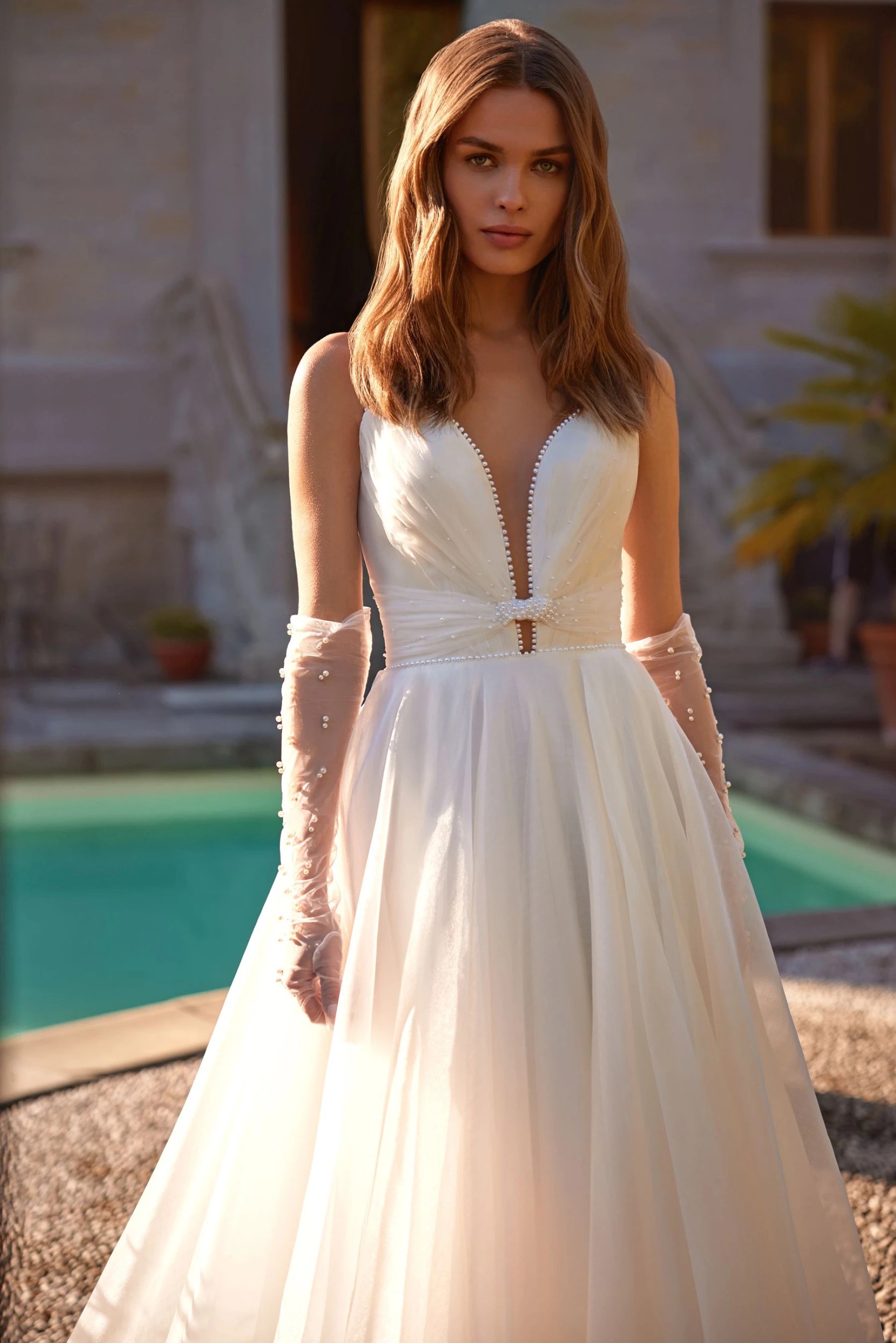 Woman wearring wedding dress - a-line with a cat eye/sweetheart neckline, close up front view