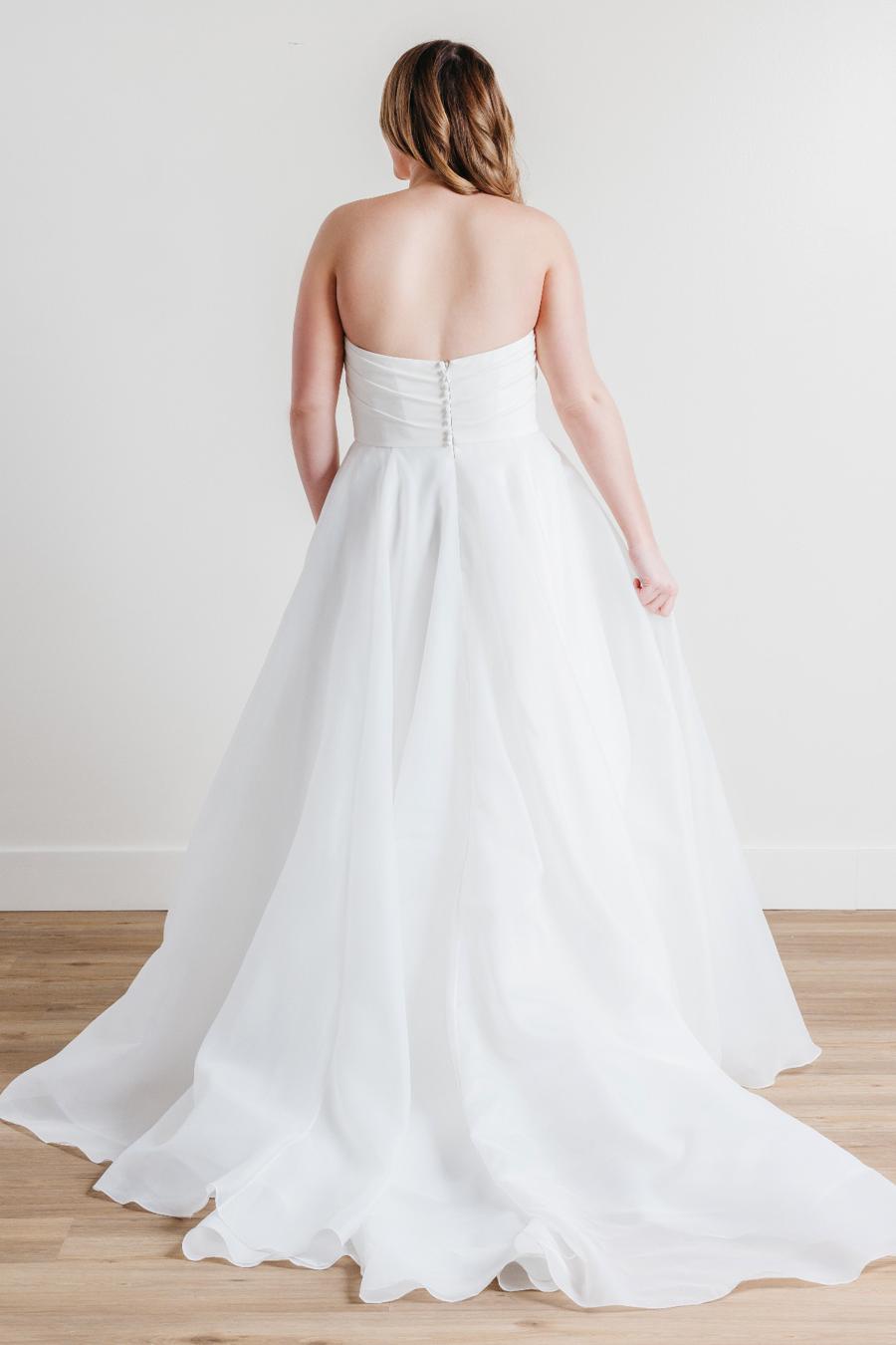 Introducing Fortune, the epitome of elegance and sophistication in bridal fashion. This exquisite wedding dress boasts a timeless strapless design, crafted with meticulous attention to detail. Its luxurious blend of Cyrus Stretch Crepe and Sluler Satin Organza fabrics creates a breathtaking A-line silhouette that will make any bride feel like a true vision of romance on her special day. 