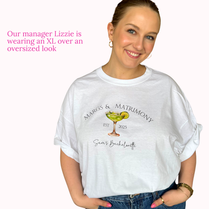 Woman wearing a white t-shirt with a graphic design and text, standing against a plain background.