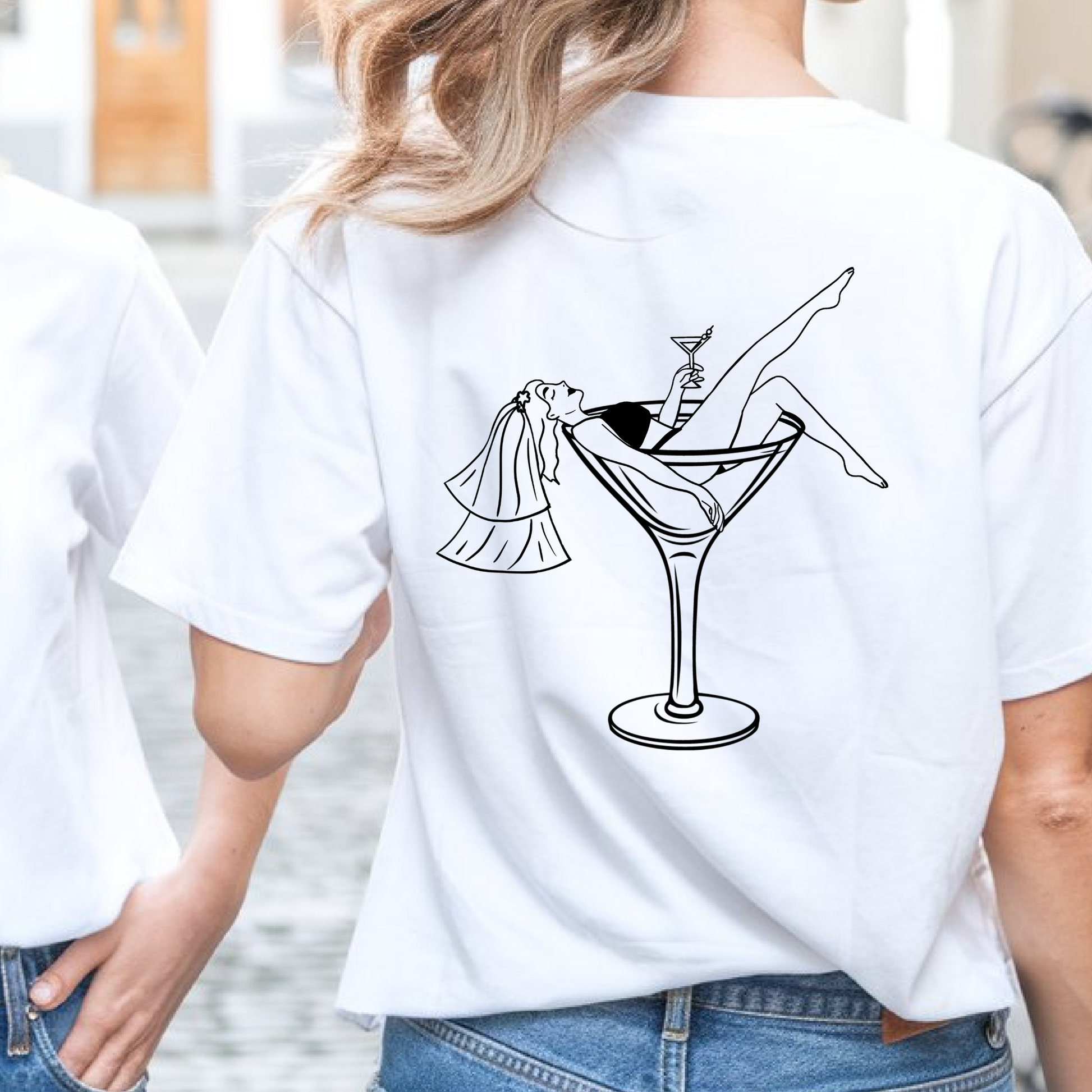 White t-shirt with a black graphic design on the back, worn by a person.