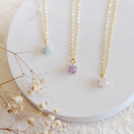 The amethyst and amazonite necklaces on a white backdrop