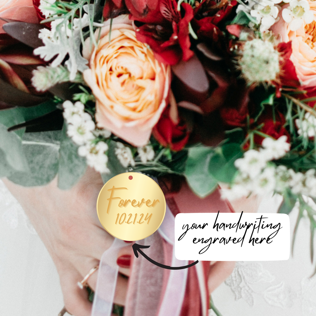 A bouquet with a gold circular charm that says "forever 10.21.24"