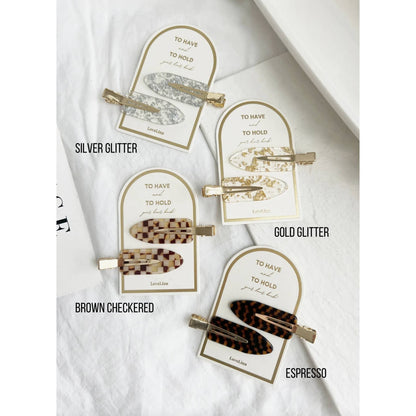Crease free hair clips ona. gold and white backing that says "To Have and To Hold Your Hair Back"