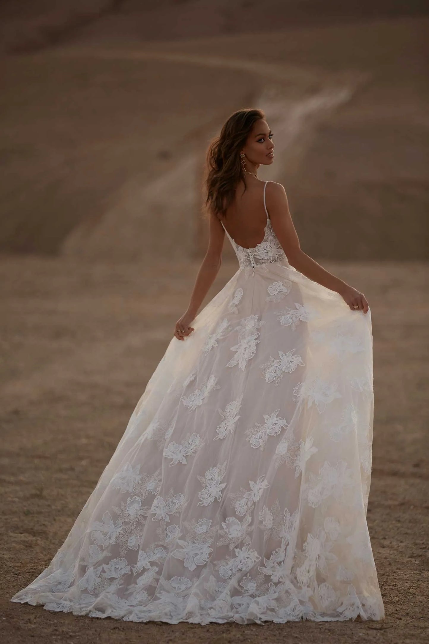 Young woman wearing a floral a line wedding dress, full body back view
