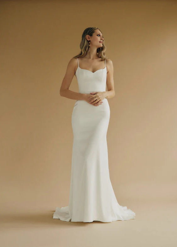 A fitted satin wedding gown with a sweetheart bodice and buttons down the back - full body view
