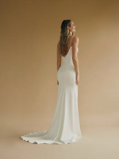 A fitted satin wedding gown with a sweetheart bodice and buttons down the back.
