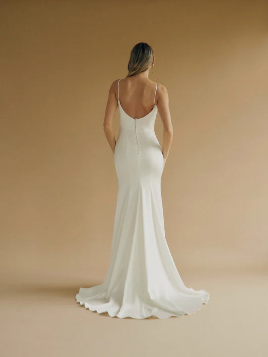 A fitted satin wedding gown with a sweetheart bodice and buttons down the back.
