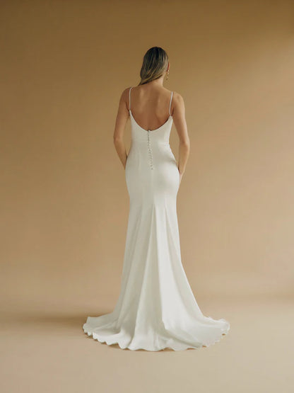 A fitted satin wedding gown with a sweetheart bodice and buttons down the back.