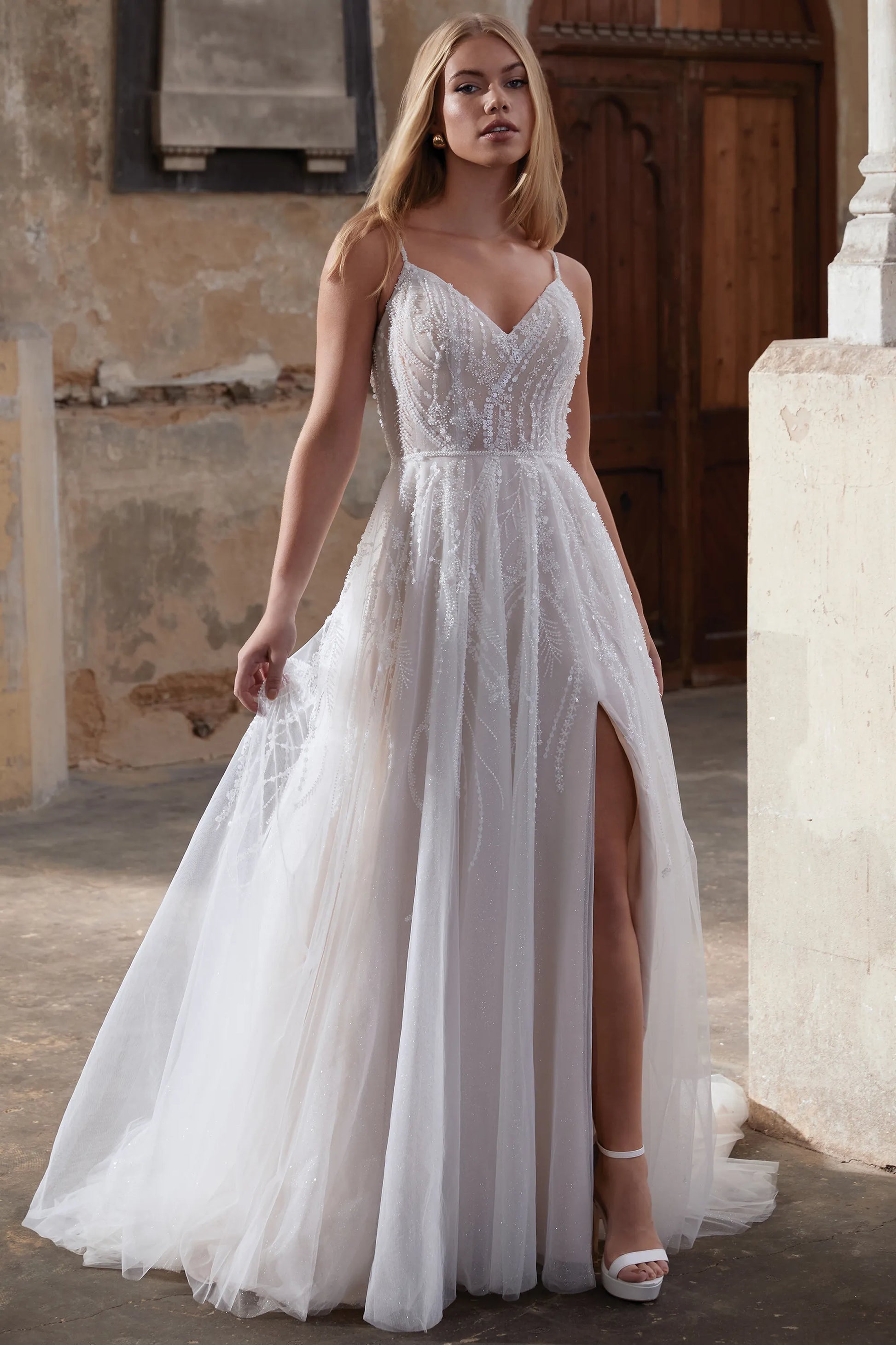 Front of the Angelina Gown Sparkle Tulle A-Line Wedding Dress with Sheer Bodice showing the slit available at NKIN in Ottawa