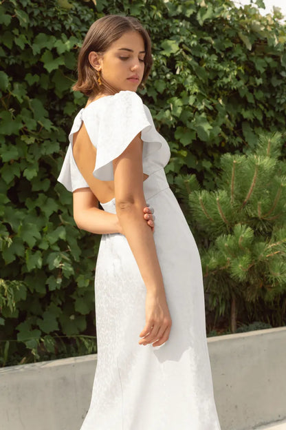 The Audrina dress showcases dramatic flutter sleeves, a flattering V-neckline with a cummerbund waist, and a slinky bias-cut skirt. The open keyhole back adds a modern twist to this romantic and vintage-inspired midi dress crafted&nbsp;from our lustrous satin jacquard.
