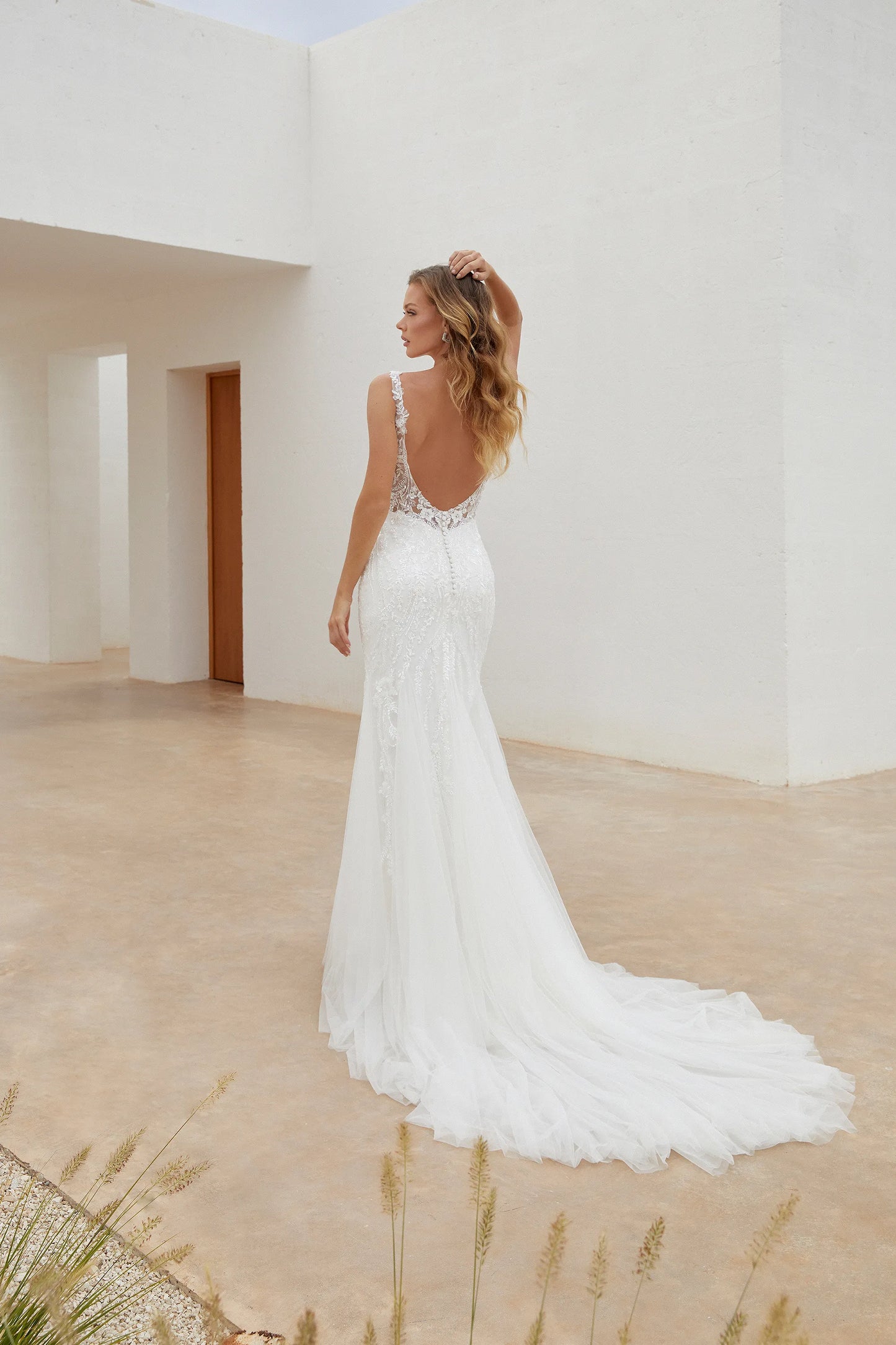 Back of the Square Neck wedding dress with all over beaded and sequined fit and flare in Ottawa Canada at NKIN. Low scooped back lace dress with chapel train