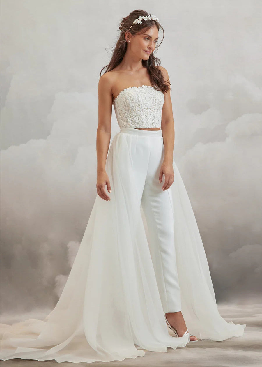 Elevate your bridal look with the full length Blaze Detachable Skirt, cut from 100% silk Organza in a rich ivory hue. The semi-sheer fabric features pleats at the waistband that adds volume as it drapes to the floor. The back of the waist ties into a bow with tails that draw the eye to the sweeping train.