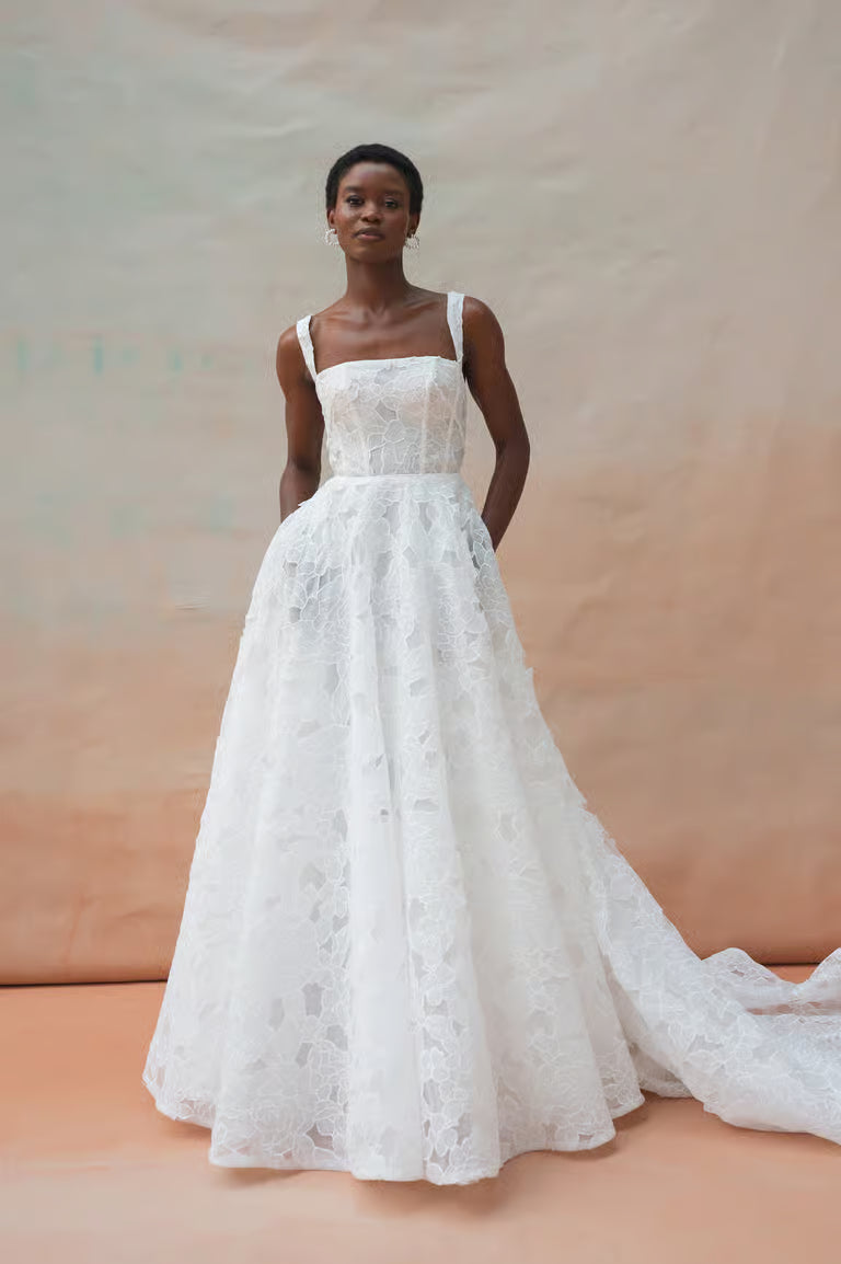Intricately textured cut out floral organza fabric is cut into clean lines with a dramatic silhouette for the strikingly romantic Charlie gown. Slightly tapered straps and a straight neckline create a sharp square neckline supported by a sculpted corse
