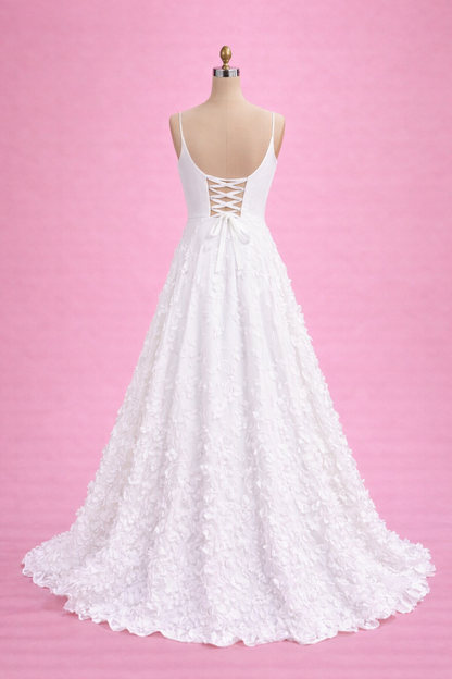 White lace wedding dress on a mannequin against a pink background