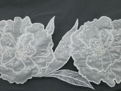Decorative fabric trim with floral patterns and sequins on a black background
