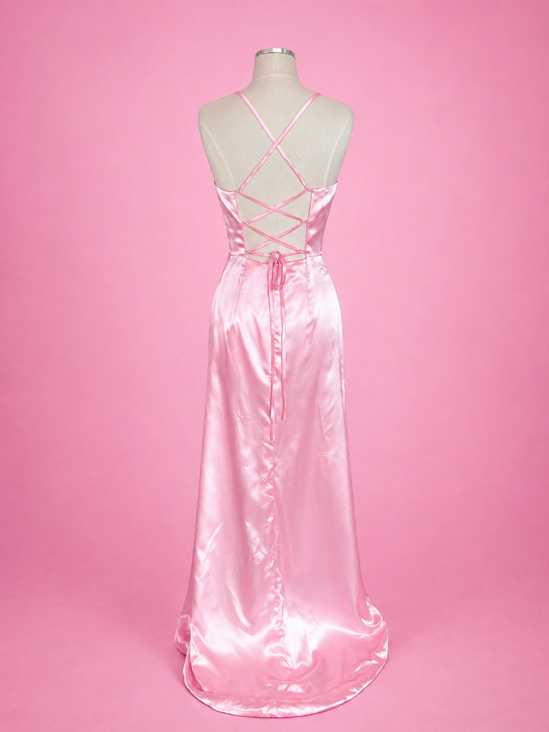 Pink satin evening gown on a mannequin against a pink background
