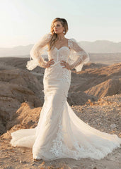 Young woman wearing Estele by All Who Wander - a fitted lacey wedding dress with puff sleeves